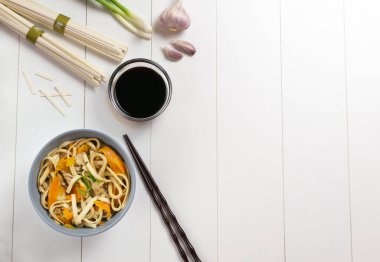 Tavuklu Udon eriştesi, soya sosu ve beyaz tabakta taze malzemeler. Üst Manzara. Japon mutfağı. Boşluğu kopyala.