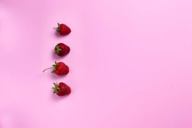 Renkli arka planda olgun çilekler. Uzayı kopyala Üst Manzara. Yatay yönelim.