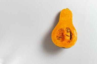 Beyaz bir arka planda dilimlenmiş tohumlu ve posalı balkabağı. Uzayı kopyala Seçici odaklanma. Minimalizm.