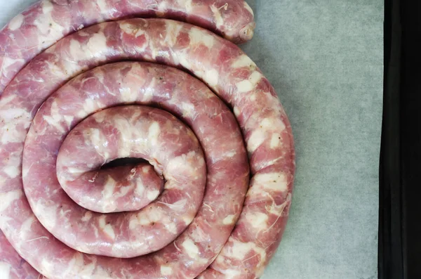 Çiğ sosis, et ve pastırma parçaları beyaz bir masanın üzerinde. Geleneksel gıda konsepti. Yatay oryantasyon. Seçici odaklanma. Üst görünüm