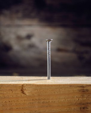 bir ahşap yüzeyde metal çivi çekiç