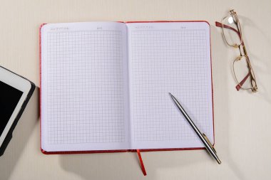 defter gözlük kalem ve tabla masaya vardır