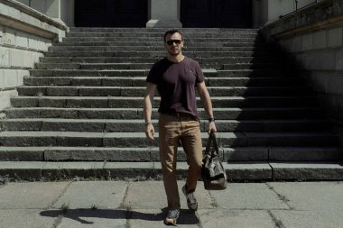 bir adam cadde boyunca bir çanta ile yürüyor