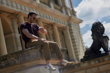 sokakta çanta ile oturan adam