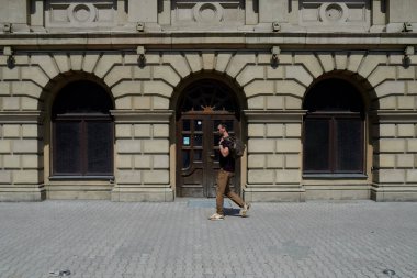 bir adam cadde boyunca bir çanta ile yürüyor