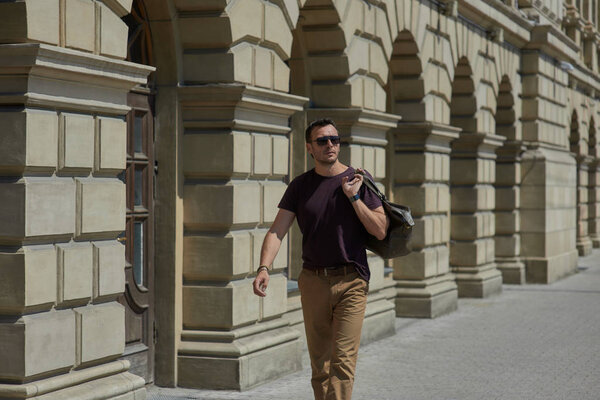 a man walks with a bag along the street