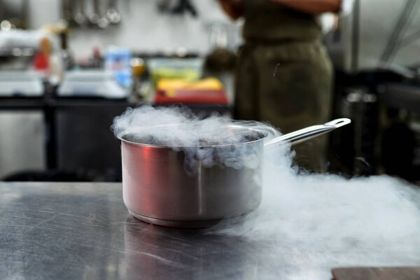 Liquid Nitrogen in a pan. Cooking. Steam. Cook. Against the background. Everything happens in the kitchen.