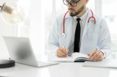 Dizüstü bilgisayar ve elektronik tıbbi kayıt (Emr) sistemi kullanarak doktor. Hastanın sağlık ve kişisel bilgi bilgisayar ekranında dijital veritabanı. El yazılı rapor.