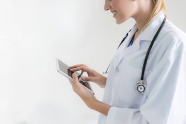 Kadın doktor oturma ise tablet bilgisayar kullanarak. Yansıtıcı cam masa bir hekim çalışma yerdir. Sağlık, sigorta ve tıp kavramı.