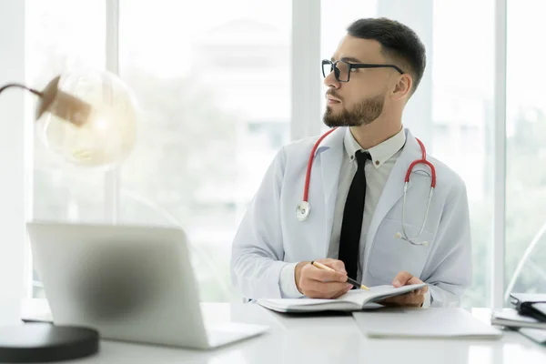 Médico Trabajando Con Computadora Portátil Escribiendo Sobre Papeleo Con Estetoscopio — Foto de Stock