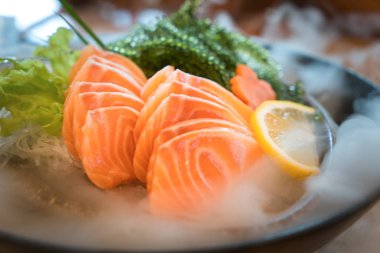 Çiğ somon dilimi veya Japon tarzı taze somon balığı hizmet kase buz üstünde.