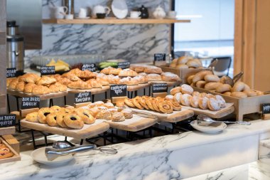 Farklı lezzet danishs, çörekler ve kekler ahşap tepsilerine otel restoranında kahvaltı satırları