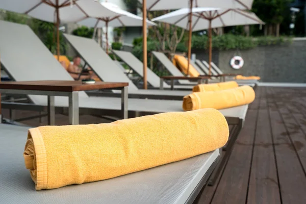 Zusammengerolltes Orangefarbenes Handtuch Auf Einer Sonnenliege Hintergrund Des Pools Resort — Stockfoto