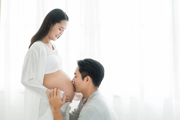 Asiatisk Man Kysser Gravid Mage Hans Fru Med Ögonen Stängda — Stockfoto