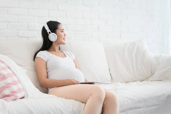 Retrato Mujer Embarazada Asiática Sentada Sofá Casa Escuchando Música Auriculares — Foto de Stock
