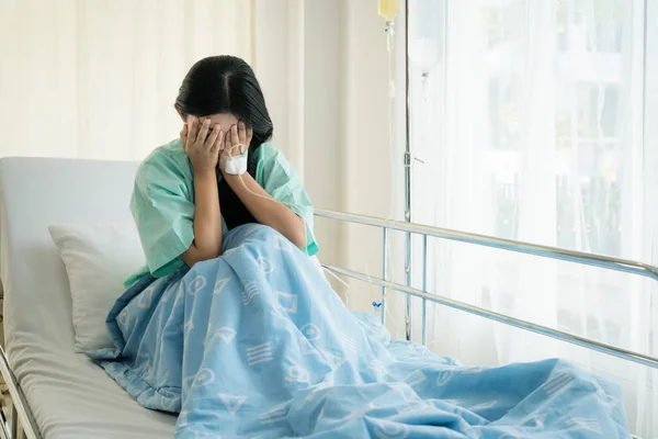 Asian young woman patient lying at hospital bed feeling sad and