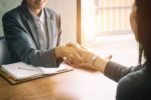 Due donne d'affari asiatiche stringono la mano su una scrivania mentre chiudono — Foto Stock