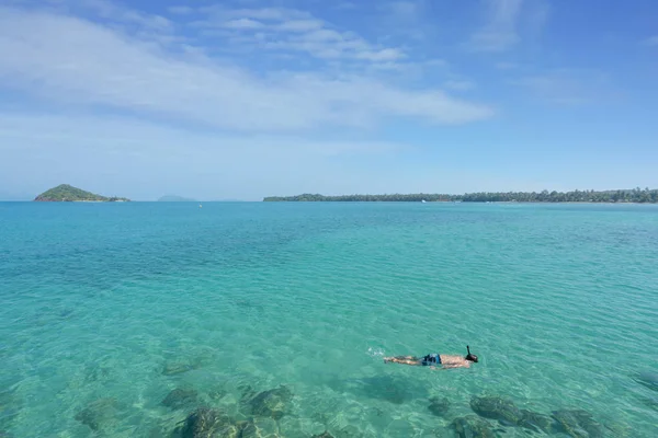 Turistas snorkel em águas cristalinas turquesa perto de resort tropical — Fotografia de Stock