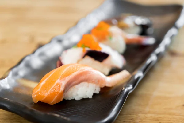 Japão sushi de salmão cru e sushi de mistura fresca definido em placa preta  - — Fotografia de Stock