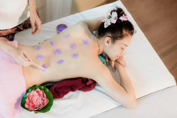 Young Asian woman receiving salt massage in spa salon, Hand putt — Stock Photo, Image