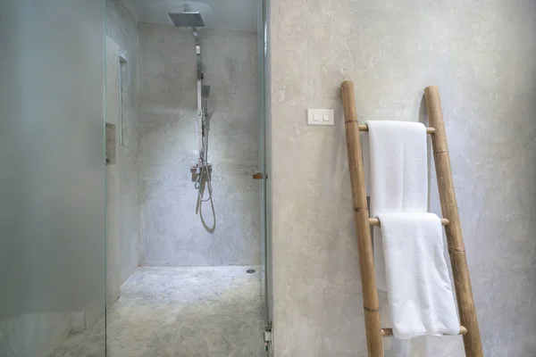 Interior del baño con cabezal de ducha moderno y toalla blanca en — Foto de Stock