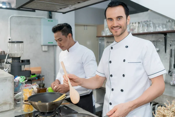 젊은 남성 요리사의 초상화 준비 스파게티 와 동료 i — 스톡 사진