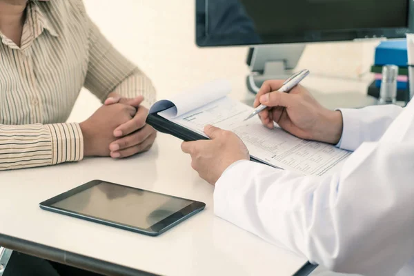 Médico masculino explicando el diagnóstico al paciente. Mujer paciente looki — Foto de Stock