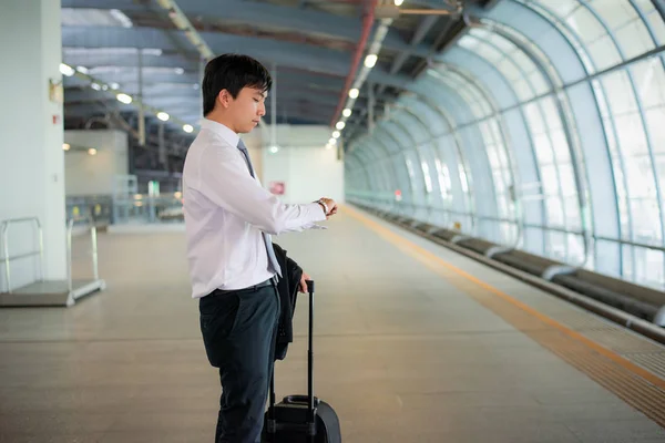 Красивий молодий азіатський бізнесмен мандрівник дивиться годинник в руці — стокове фото