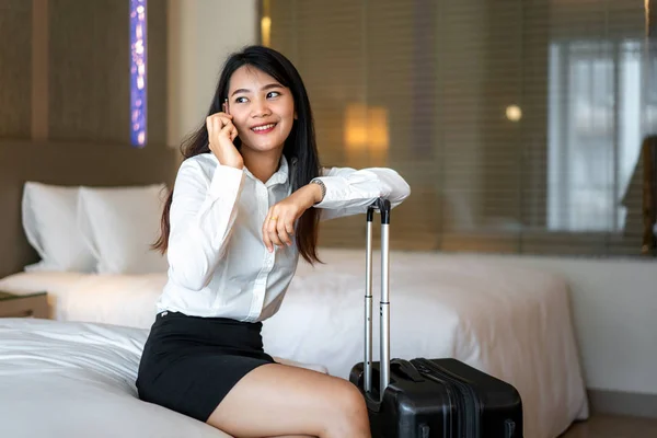 Mujer asiática leyendo mensajes telefónicos en la habitación del hotel. Ejecuti femeninos — Foto de Stock