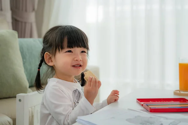 Feliz asiático niño chica con un Grande sonrisa mientras comer oblea whe — Foto de Stock