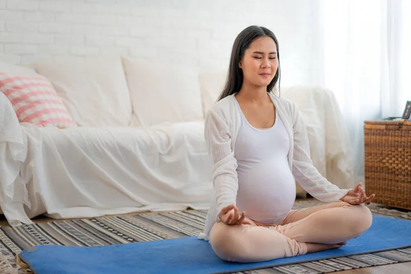 Meditar sobre la maternidad. Primer plano de mujer embarazada joven asiática — Foto de Stock