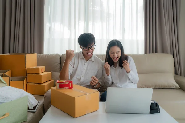 Asian man and woman are selling their online via on the computer