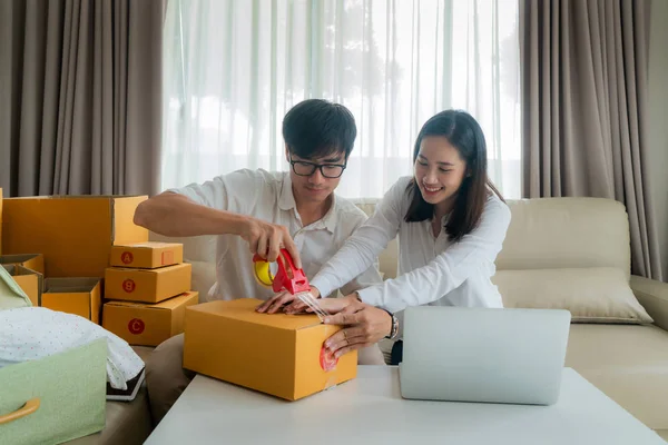 Asiatisches junges Paar verkauft online über Computer und Helferin — Stockfoto