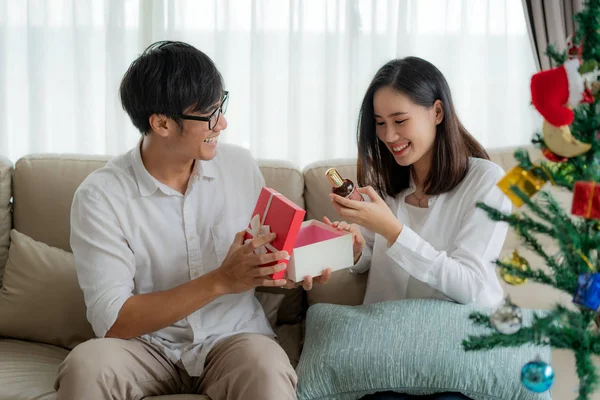 Asiático hombre dar a la mujer una caja de regalo rojo en el que hay un botín — Foto de Stock