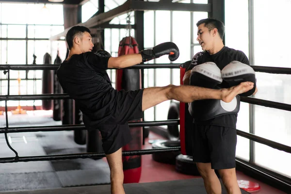 Genç Asyalı Boksör, boks antrenörünü tekmeliyor. — Stok fotoğraf