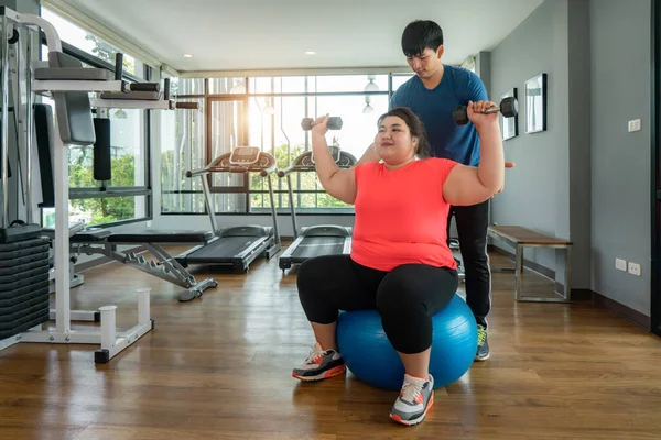 Dois ásia treinador homem e excesso de peso mulher exercício com dumbb — Fotografia de Stock