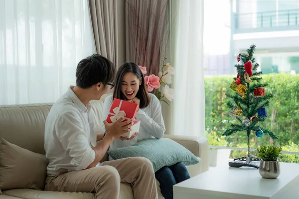Homem asiático dar à mulher uma caixa de presente vermelho em que há um bott — Fotografia de Stock