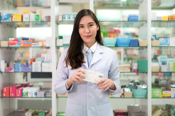 Ázsiai fiatal nő gyógyszerész egy szép barátságos mosoly holdin — Stock Fotó