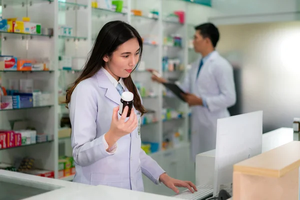 Confiante Asiático jovem farmacêutico com sorriso segurando um med — Fotografia de Stock