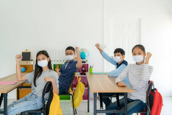 Gruppe Asiatischer Grundschüler Mit Hygienemaske Klassenzimmer Arm Erhoben Glücklich Sein — Stockfoto