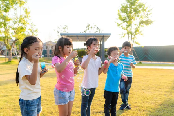 Duży Grupa Szczęśliwy Azjatycki Uśmiechnięty Przedszkole Dzieci Przyjaciele Grać Dmuchanie — Zdjęcie stockowe