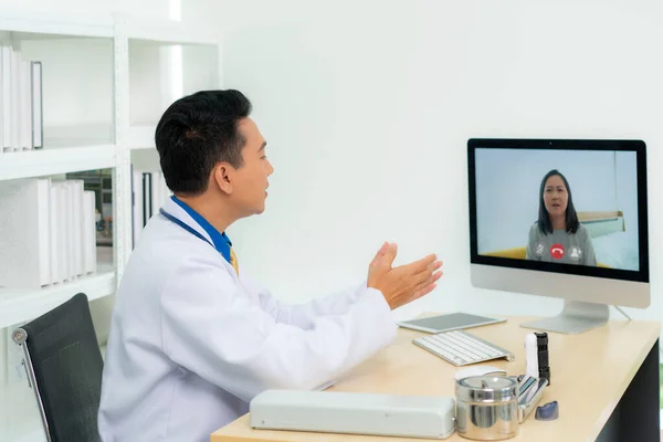 Asiático Médico Hombre Lleva Abrigo Blanco Auriculares Hablando Videoconferencia Ordenador —  Fotos de Stock