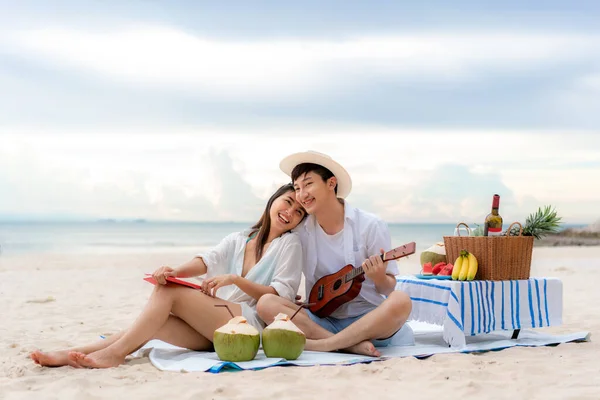 アジアのカップルは ウクレレを演奏し 一緒に歌の音楽を歌うことによって 海のビーチでカップルの恋人の旅行の新婚旅行を幸せとお楽しみください タイの夏 幸せな人々のコンセプト — ストック写真
