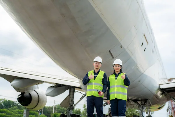 アジアの男性と女性のエンジニアのメンテナンス飛行機の親指と修理 近代化や空港での改装から前の飛行機でレンチを保持 — ストック写真