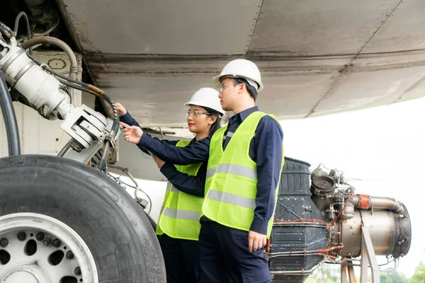 アジアの男性と女性のエンジニアのメンテナンス航空機チームの修理 近代化と空港からの前の飛行機の改装 — ストック写真