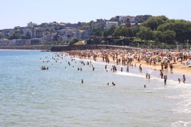 Sahilde yürüyen insanlar.