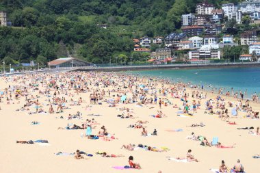 İnsanlar yazın kumsalda eğleniyor.