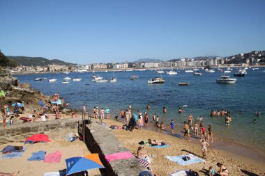 Donostia San Sebastian, Pais Vasco, 25 Ağustos 2020: Donostia Körfezi 'nin arka planında adanın kumsalında yıkanır.