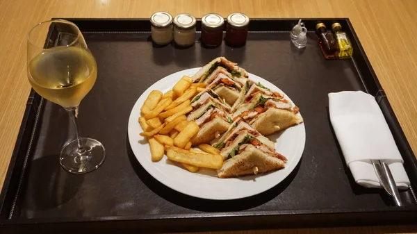 三角形にフライドポテトとワインオパとクラブサンドイッチ付きのルームサービストレイ — ストック写真