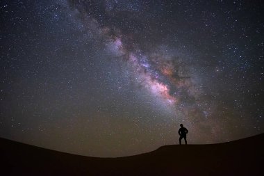 Samanyolu galaksisinin bir adamla ayakta ve Tar çöl, Jaisalmer, Hindistan izliyor. Astro fotoğraf.